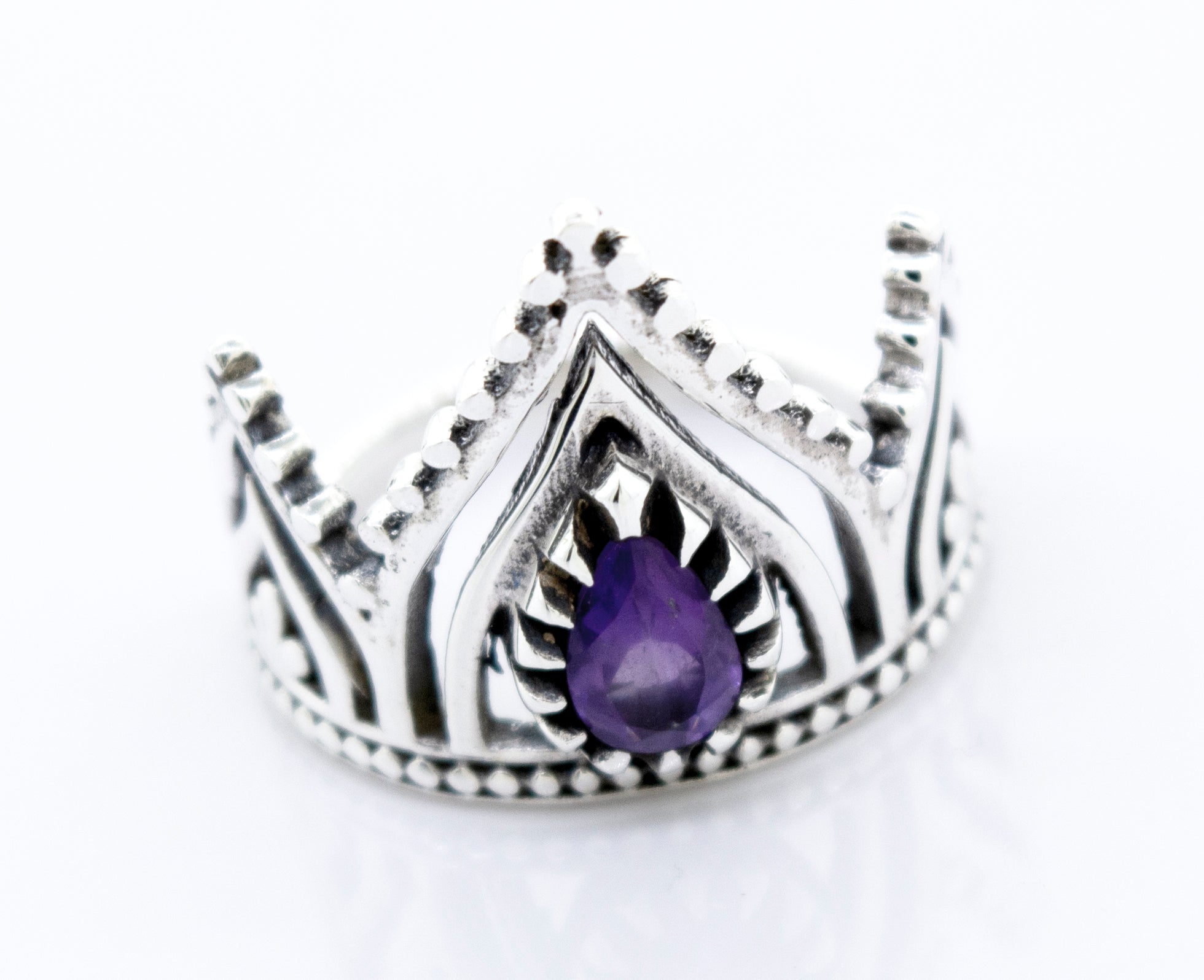 A Super Silver crown ring with a teardrop-shaped amethyst set on a white surface.