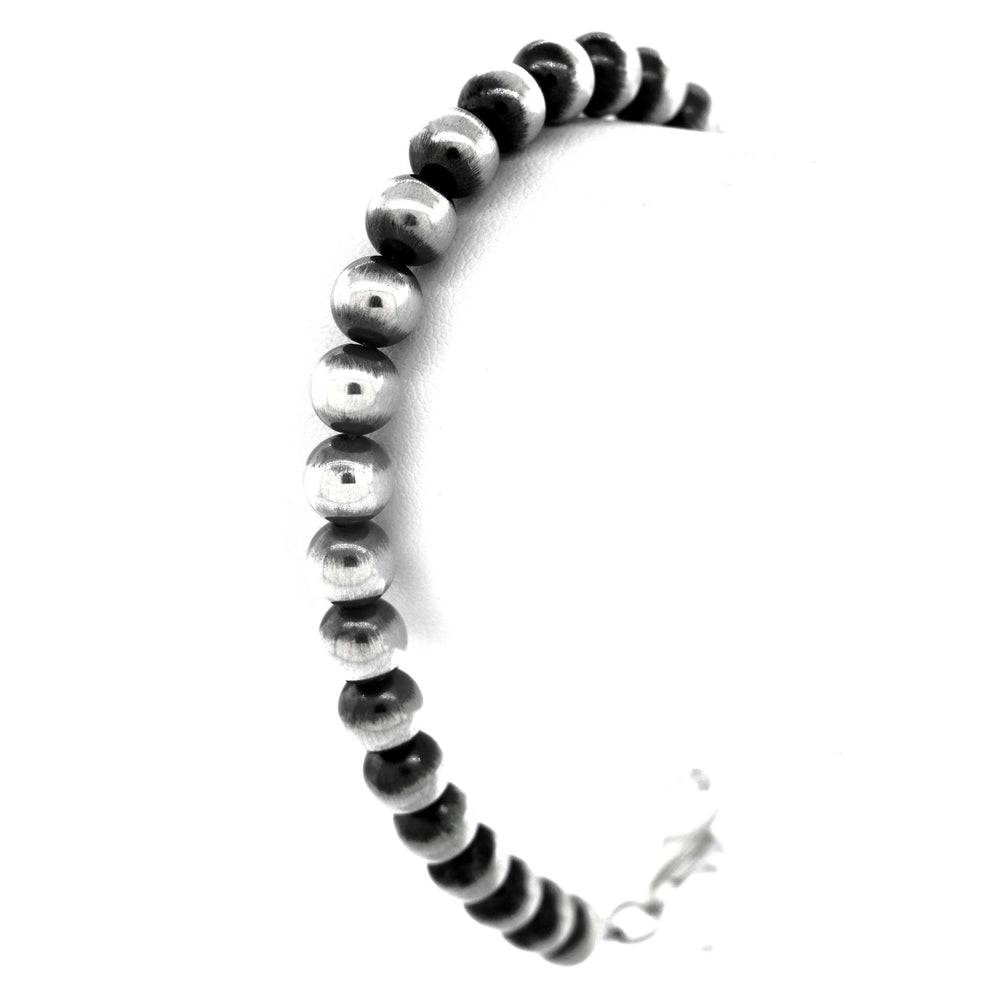 
                  
                    A Super Silver Handcrafted Navajo Pearl Bracelet with a vintage vibe, featuring elegant black and silver beads, displayed beautifully on a white background.
                  
                