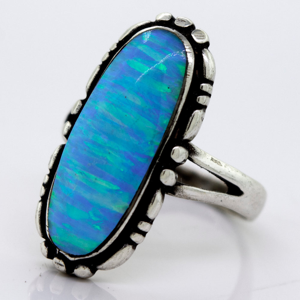 
                  
                    A Super Silver American Made Oval Opal Ring with a blue opal stone in a southwestern-styled design.
                  
                