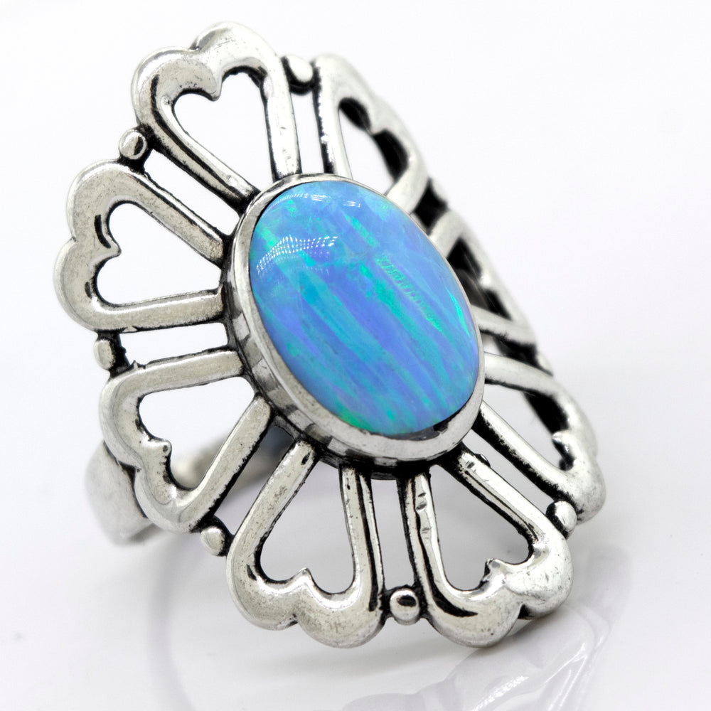 
                  
                    A Super Silver American Made Opal Flower Ring with Heart Shaped Petals, featuring a stunning blue opal in the center and a delicate flower design.
                  
                