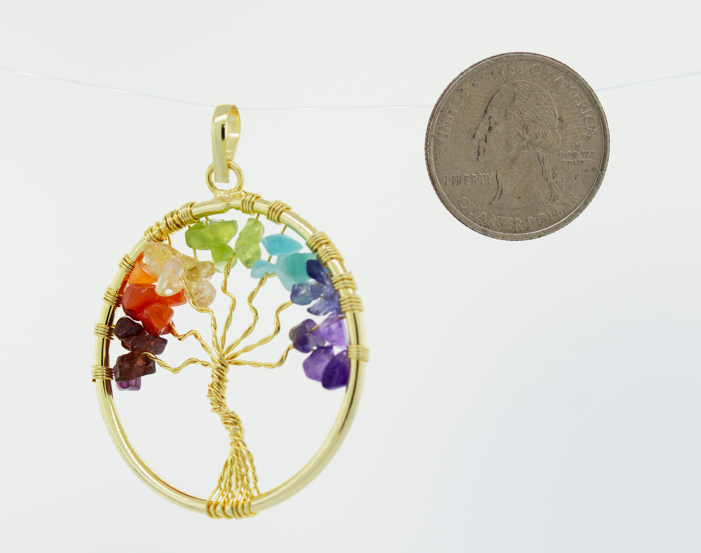 
                  
                    A Super Silver Wire-Wrapped Chakra Tree of Life pendant adorned with gold plating, accompanied by a coin.
                  
                