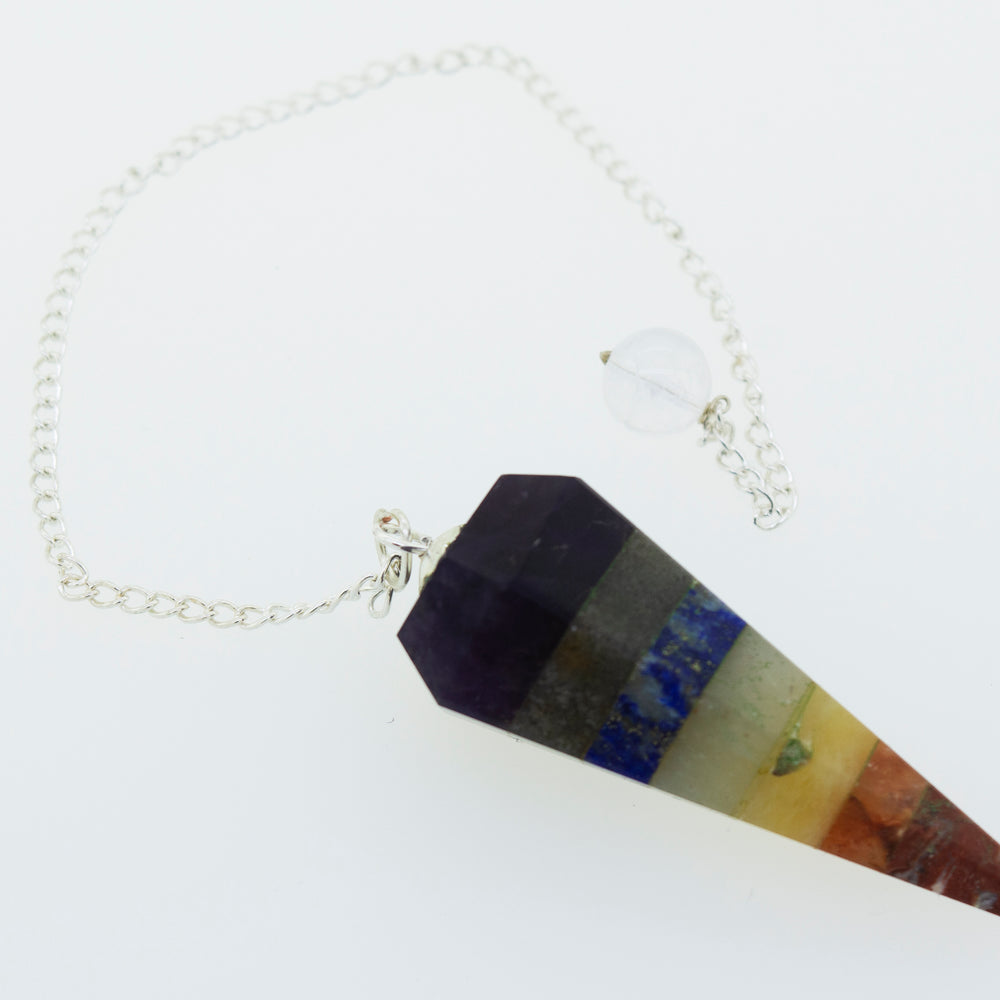A colorful necklace with a Chakra Stones Pendulum, perfect for those interested in witchcraft.