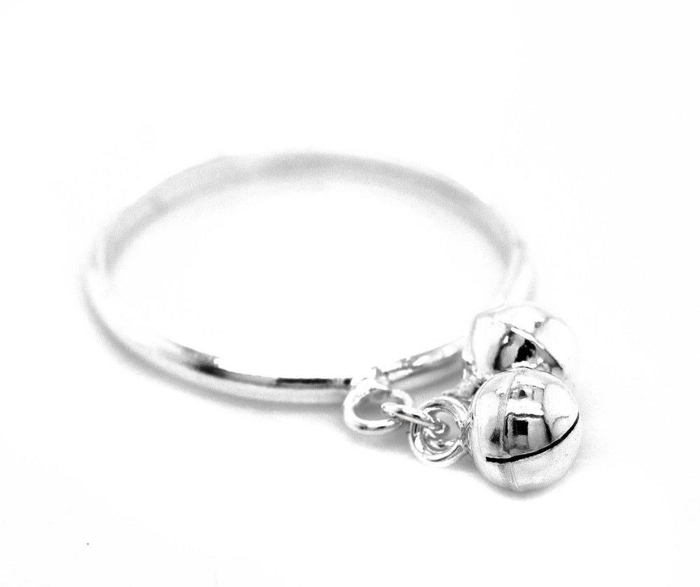 A Delicate Charm Ring with Bells from Super Silver featuring two silver balls.