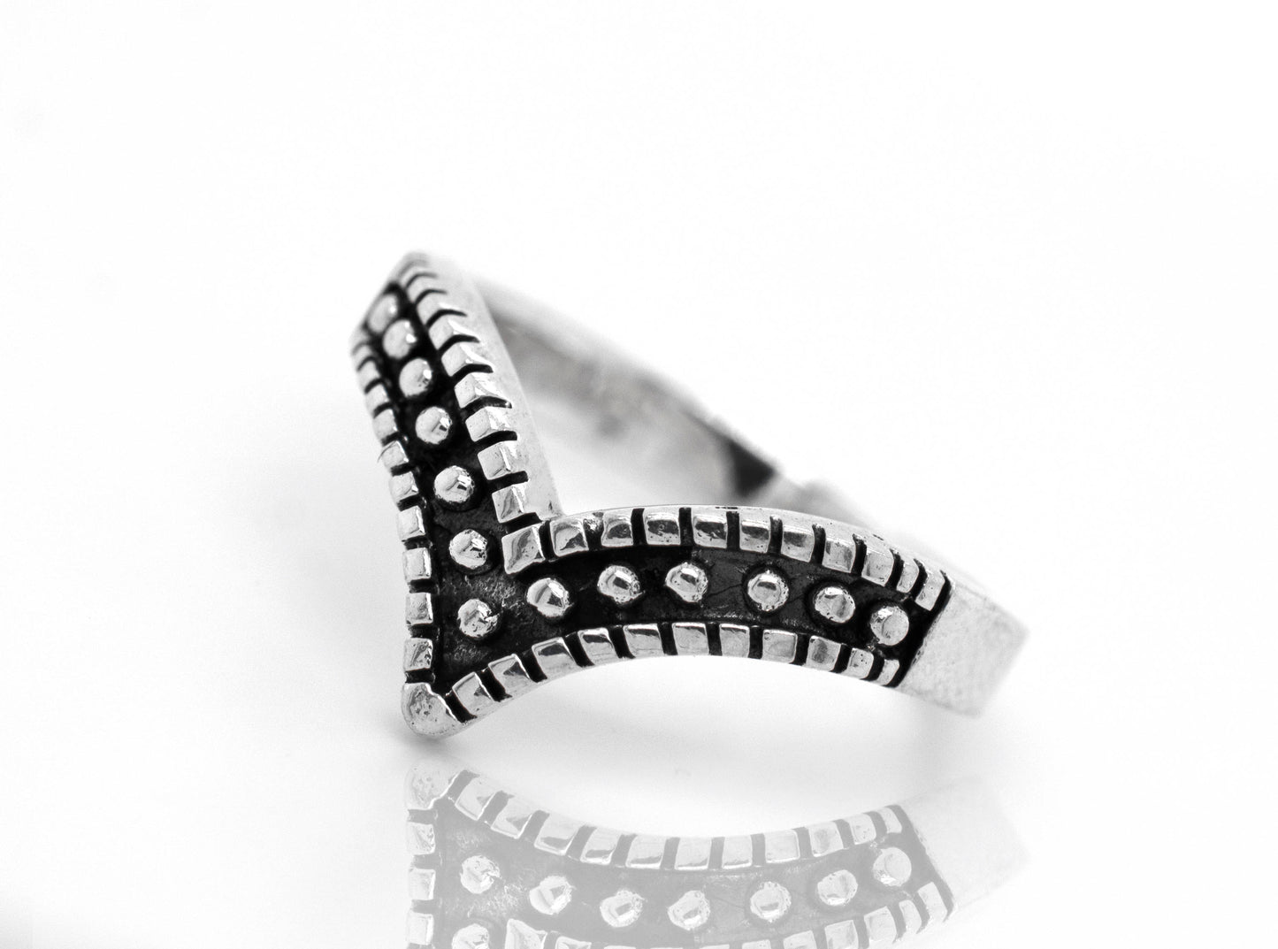 A striking chevron ring with black and white dots.