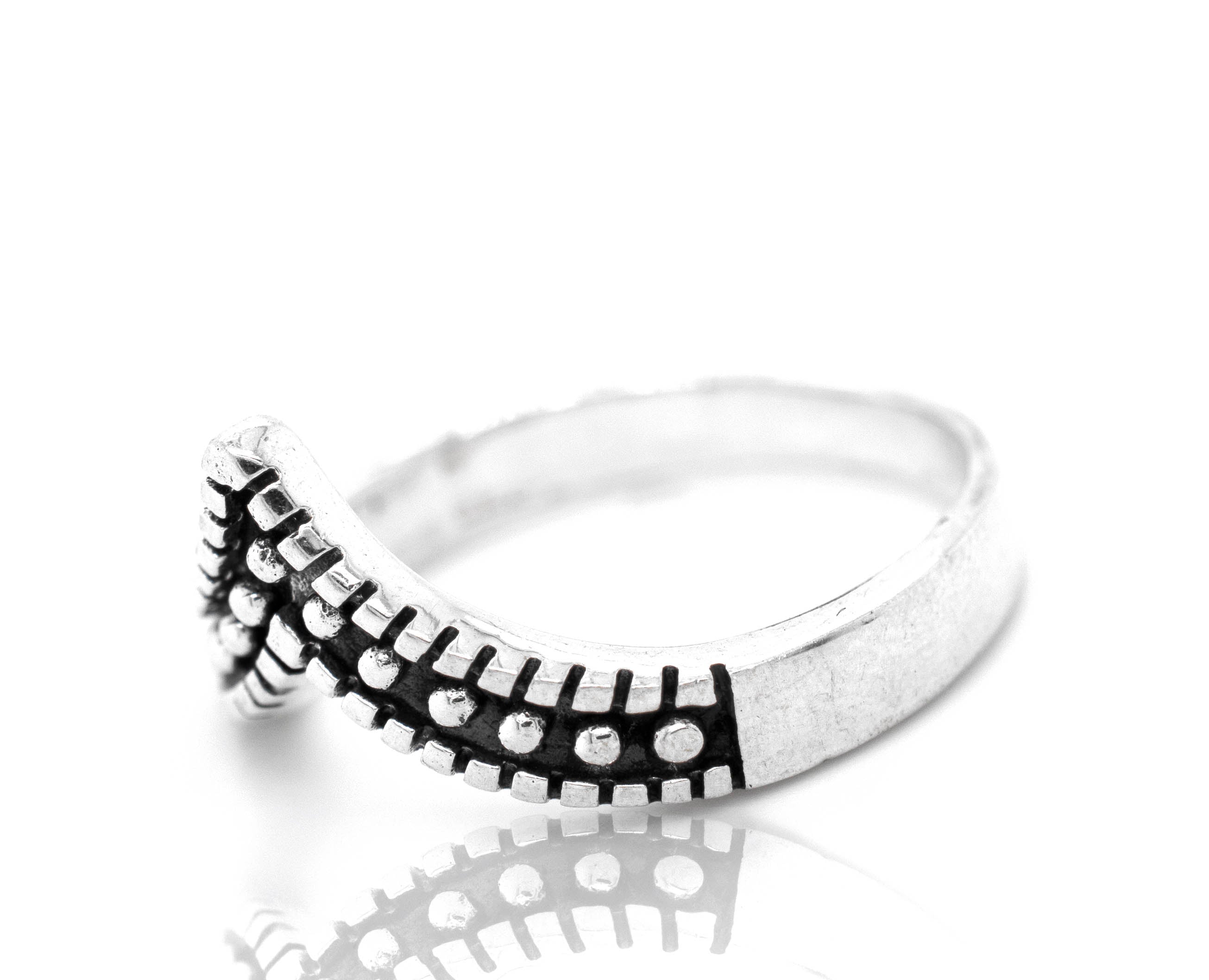 A stackable Striking Chevron Ring with black and white dots.