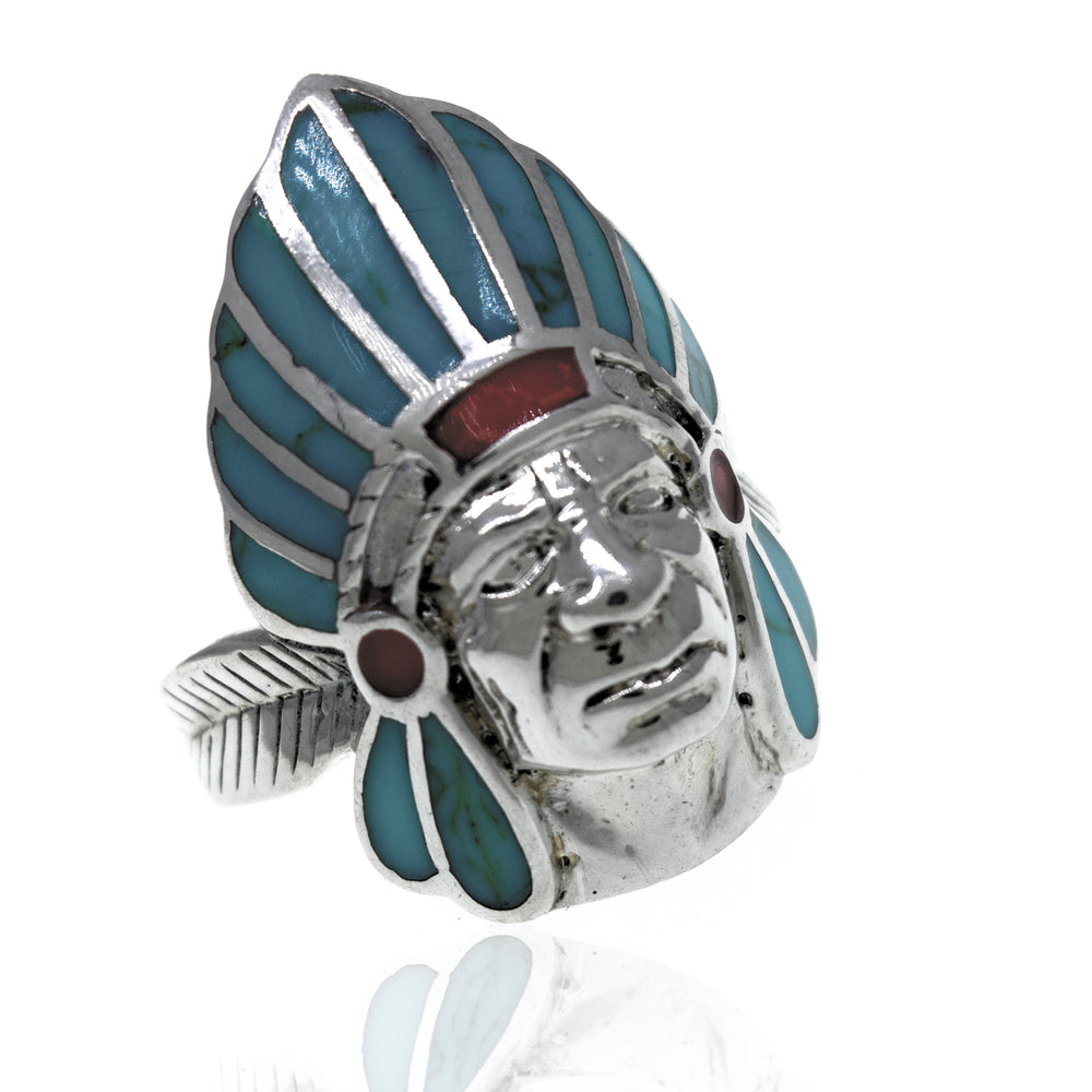 
                  
                    A sterling silver ring with a Turquoise And Coral Chief Head inlay.
                  
                