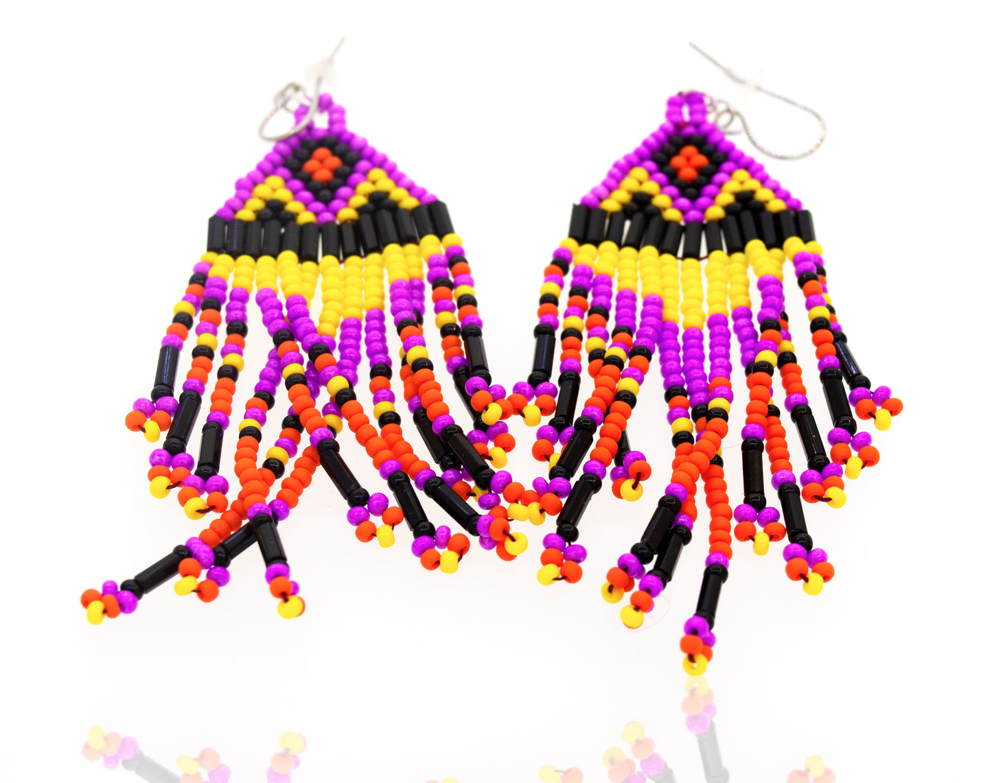 
                  
                    A pair of Super Silver southwest-inspired earrings with purple and yellow gemstone beads, displayed on a white surface.
                  
                