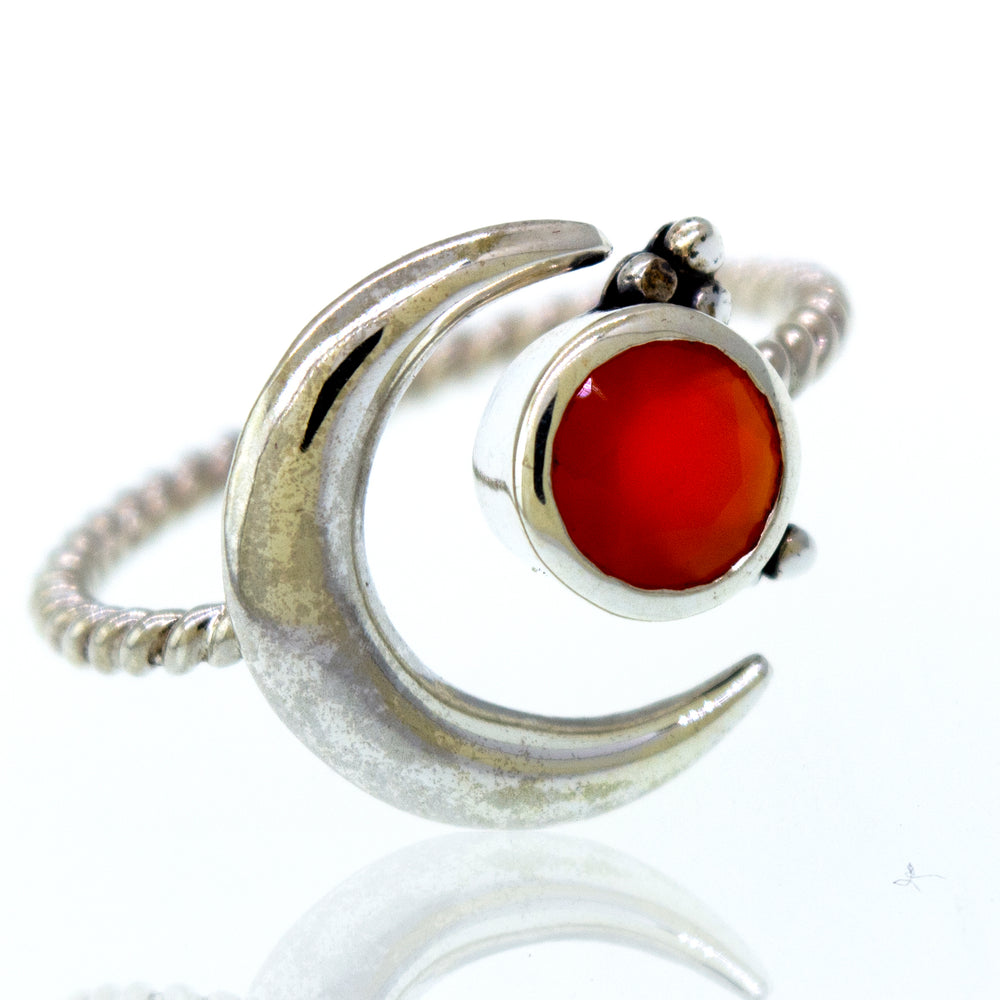 
                  
                    An Online Only Exclusive Adjustable Carnelian Ring with a silver crescent design and an orange carnelian crystal stone.
                  
                