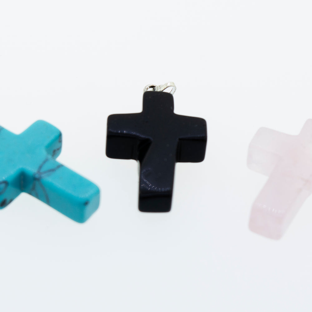 Three Super Silver Stone Cross Pendants on a white surface.