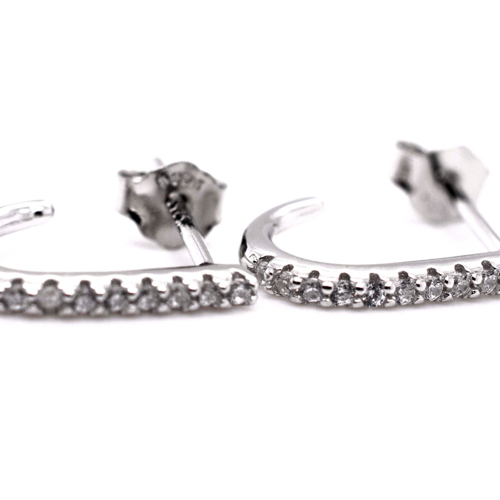 A pair of Super Silver Tiny Pave Cubic Zirconia Half Hoop Post Earrings with diamond-alternative stones.