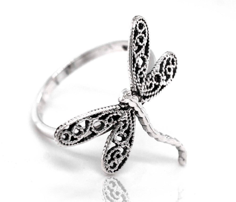 A boho-inspired Dragonfly Ring with Filigree Wings made of sterling silver, showcased on a pristine white background.