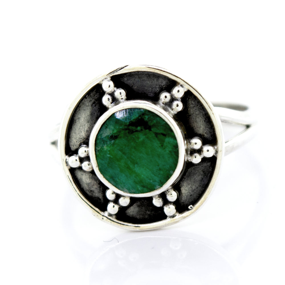 A Super Silver emerald ring with a unique oxidized silver design in the shape of an oval.