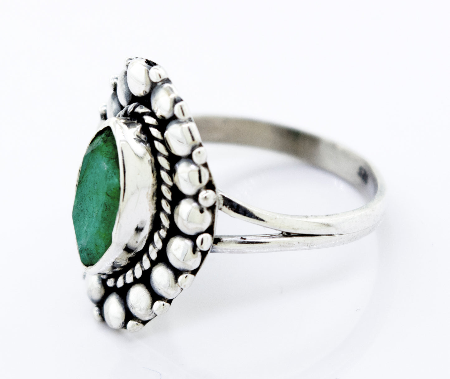 A Super Silver Marquise Shaped Vibrant Emerald Ring with an emerald stone on a white surface.