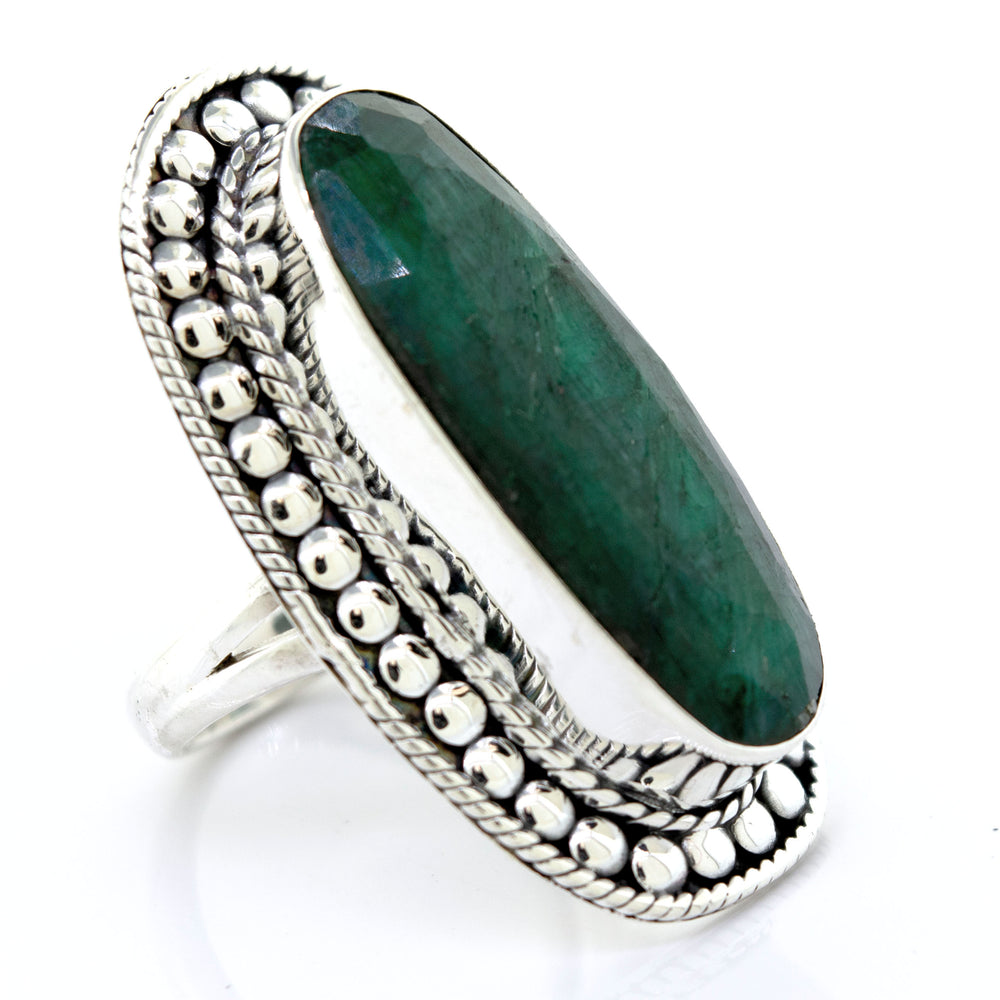 An Elegant Raw Emerald Ring with an oval emerald stone on a white background, by Super Silver.