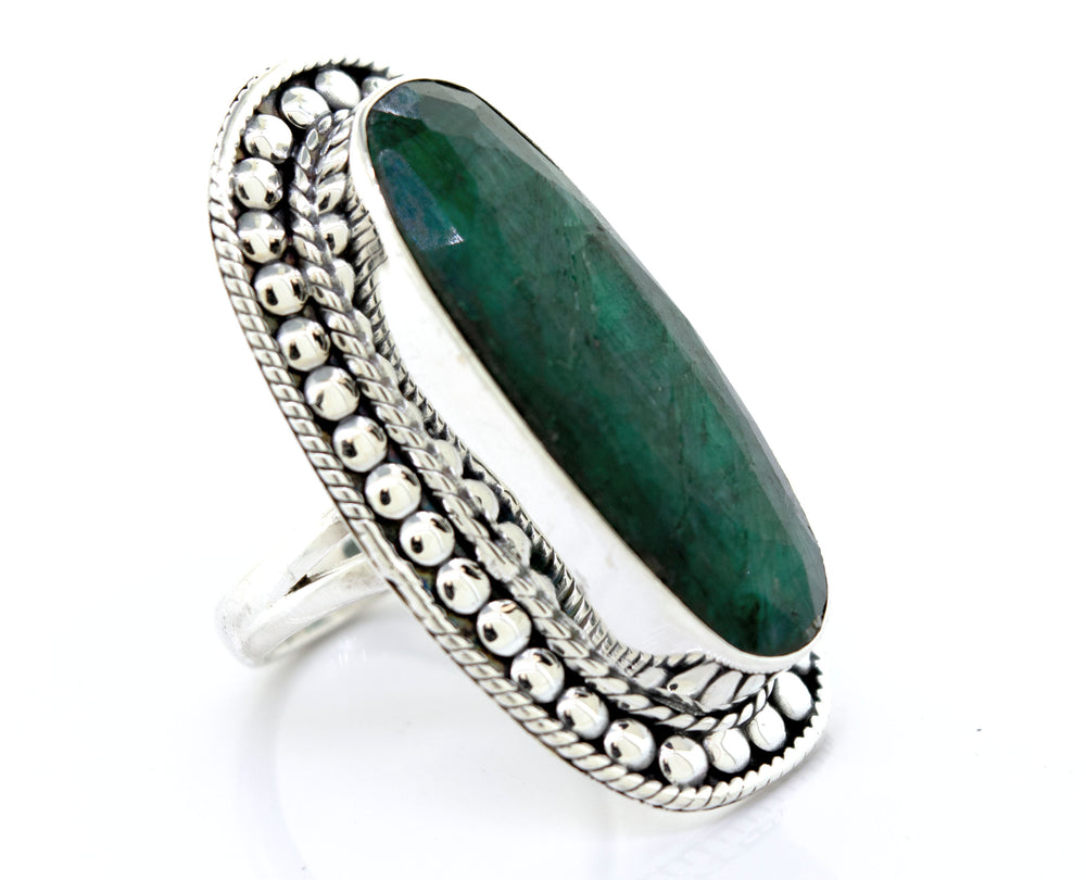 An Elegant Raw Emerald Ring with an oval emerald stone on a white background, by Super Silver.