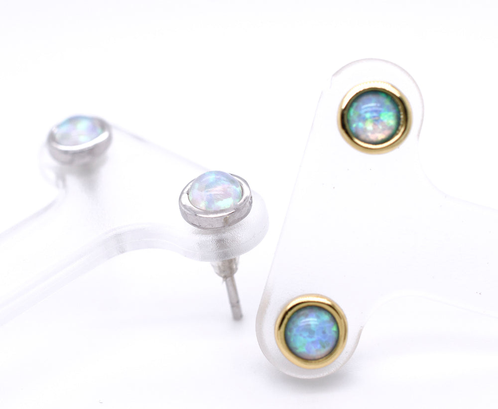 
                  
                    A pair of Radiant Australian Opal Studs by Super Silver, showcasing brilliant colors, on a white surface.
                  
                