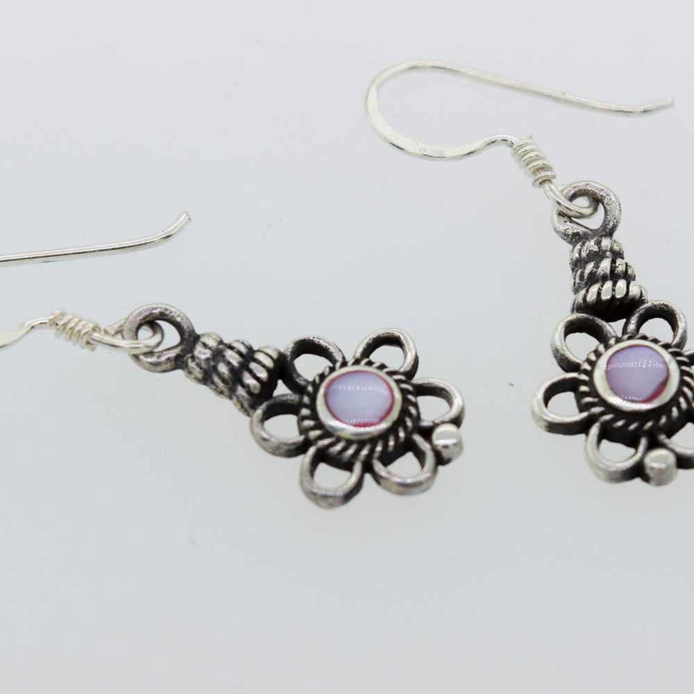 
                  
                    A pair of Flower Design Earrings with a round purple stone by Super Silver.
                  
                