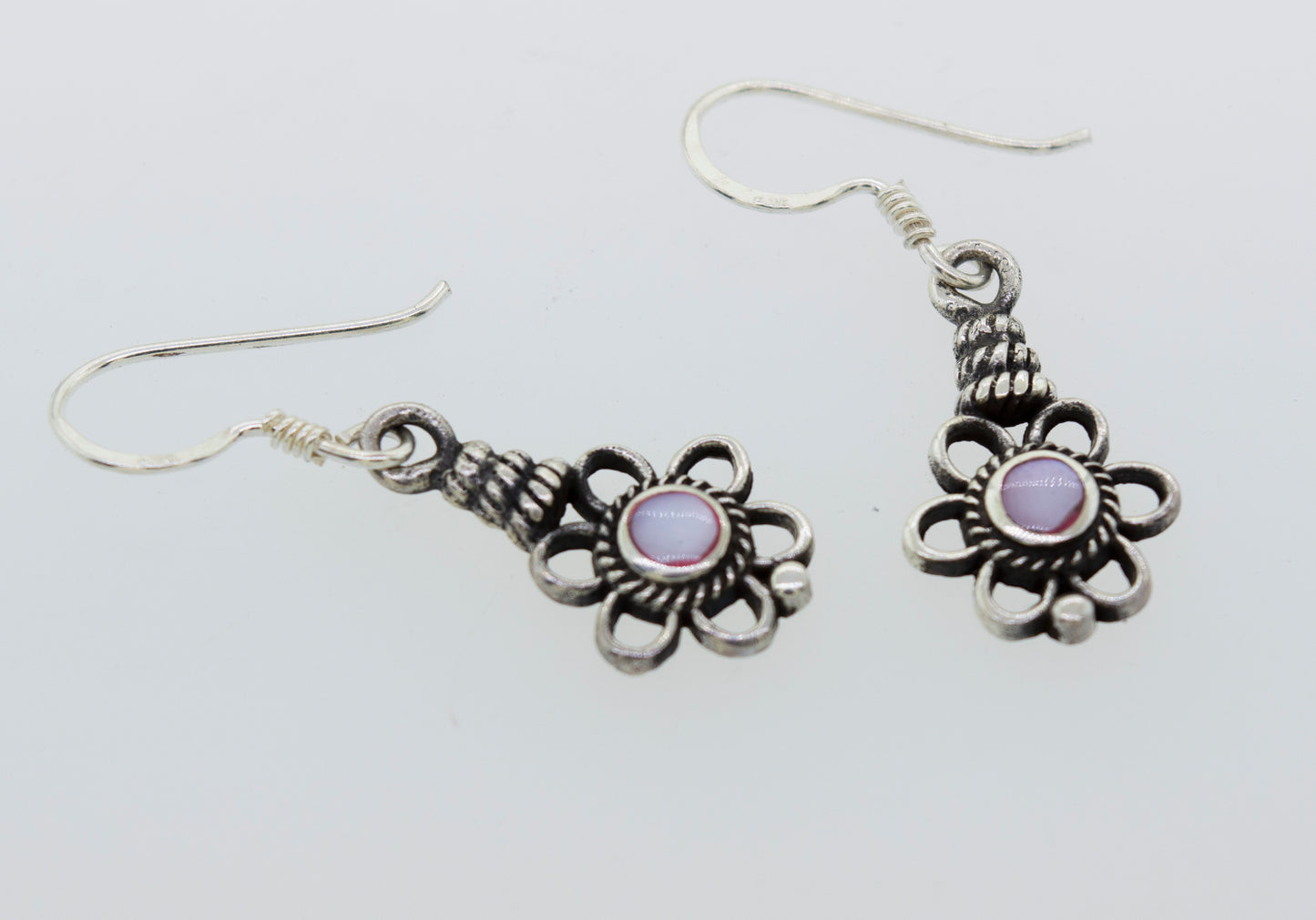 
                  
                    A pair of Flower Design Earrings with a round purple stone by Super Silver.
                  
                
