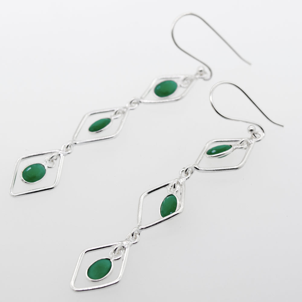 Super Silver's Wire Diamond Earrings with Emerald, measuring 2.5 inches long, are crafted in sterling silver.