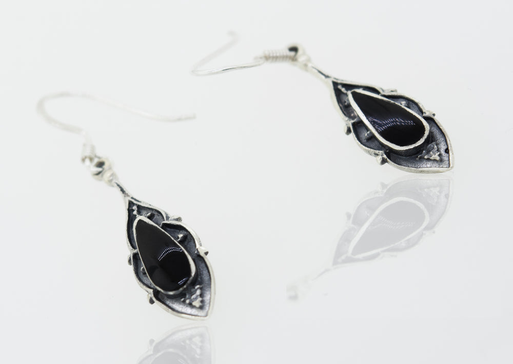A pair of Super Silver teardrop shape onyx earrings featuring onyx stones on a white surface.