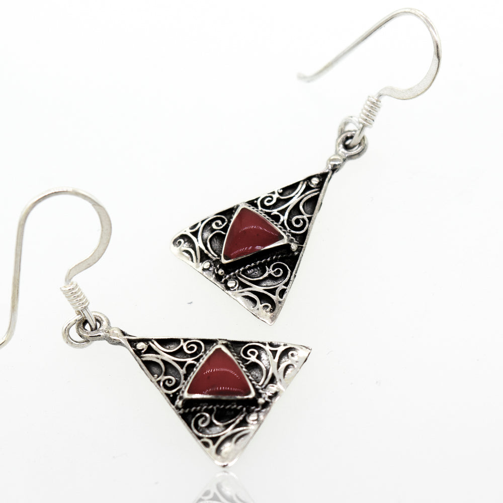 These Freestyle Design Triangle Shape Coral Earrings from Super Silver feature a stunning red coral stone in the middle.