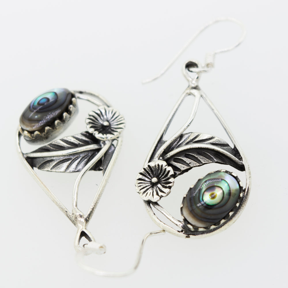 These stunning Abalone Teardrop Earrings With Floral Setting by Super Silver feature a beautiful flower and leaf design, crafted in sterling silver and adorned with mesmerizing black Abalone shells.