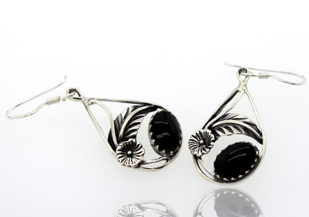 A pair of black Super Silver Onyx Teardrop Earrings With Floral Setting made of 925 Sterling Silver on a white surface.