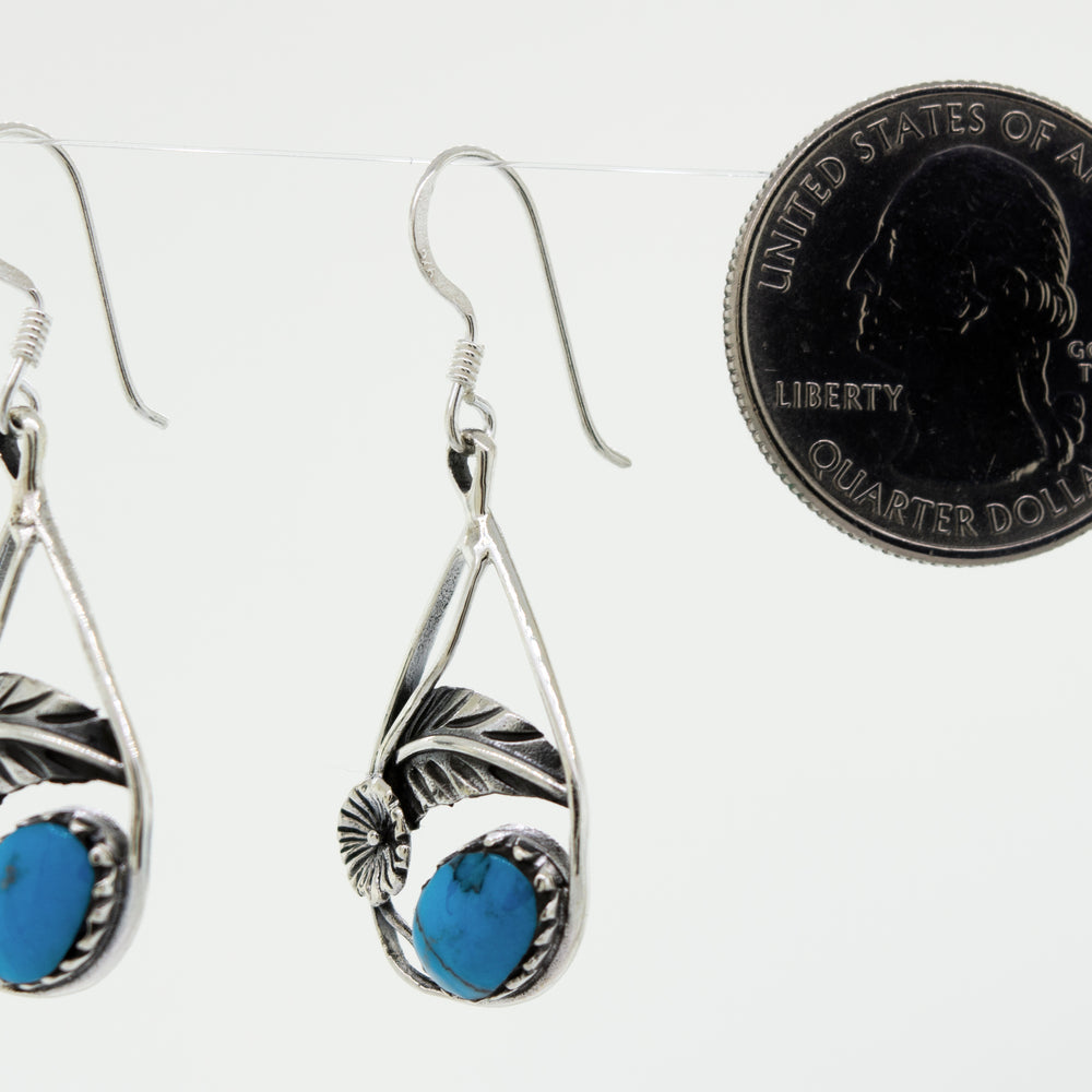 These Blue Turquoise Teardrop Earrings With Floral Setting from Super Silver feature a crown setting with stunning turquoise stones.