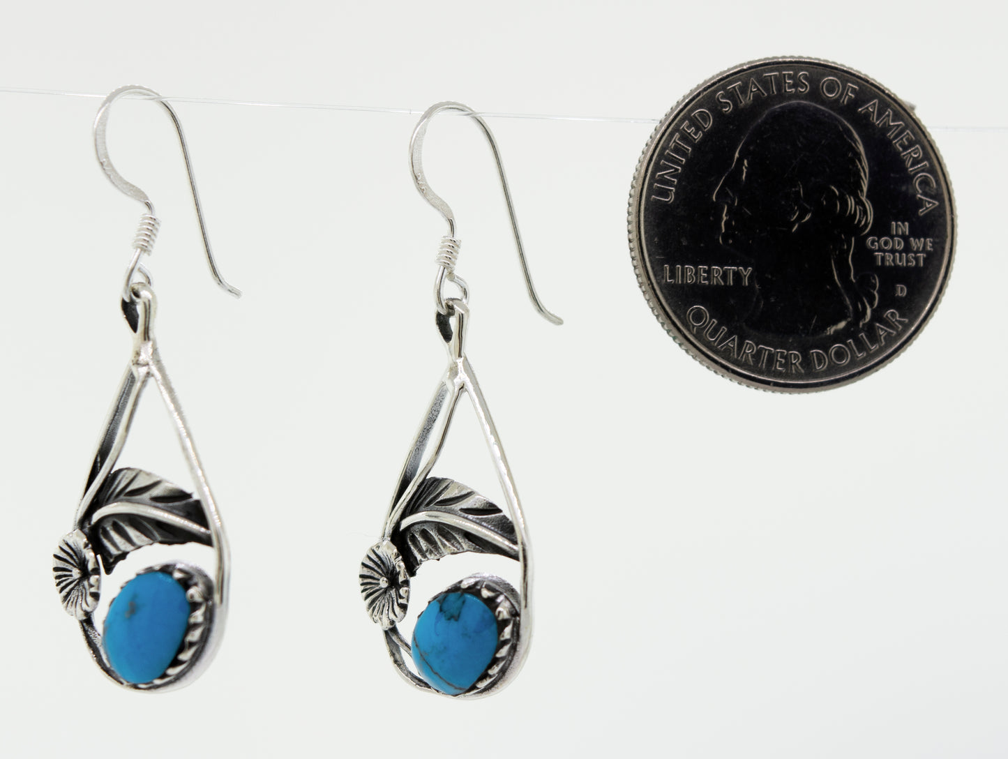 These Blue Turquoise Teardrop Earrings With Floral Setting from Super Silver feature a crown setting with stunning turquoise stones.
