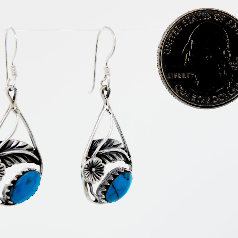 
                  
                    A pair of Blue Turquoise Teardrop Earrings With Floral Setting by Super Silver with a quarter accent.
                  
                
