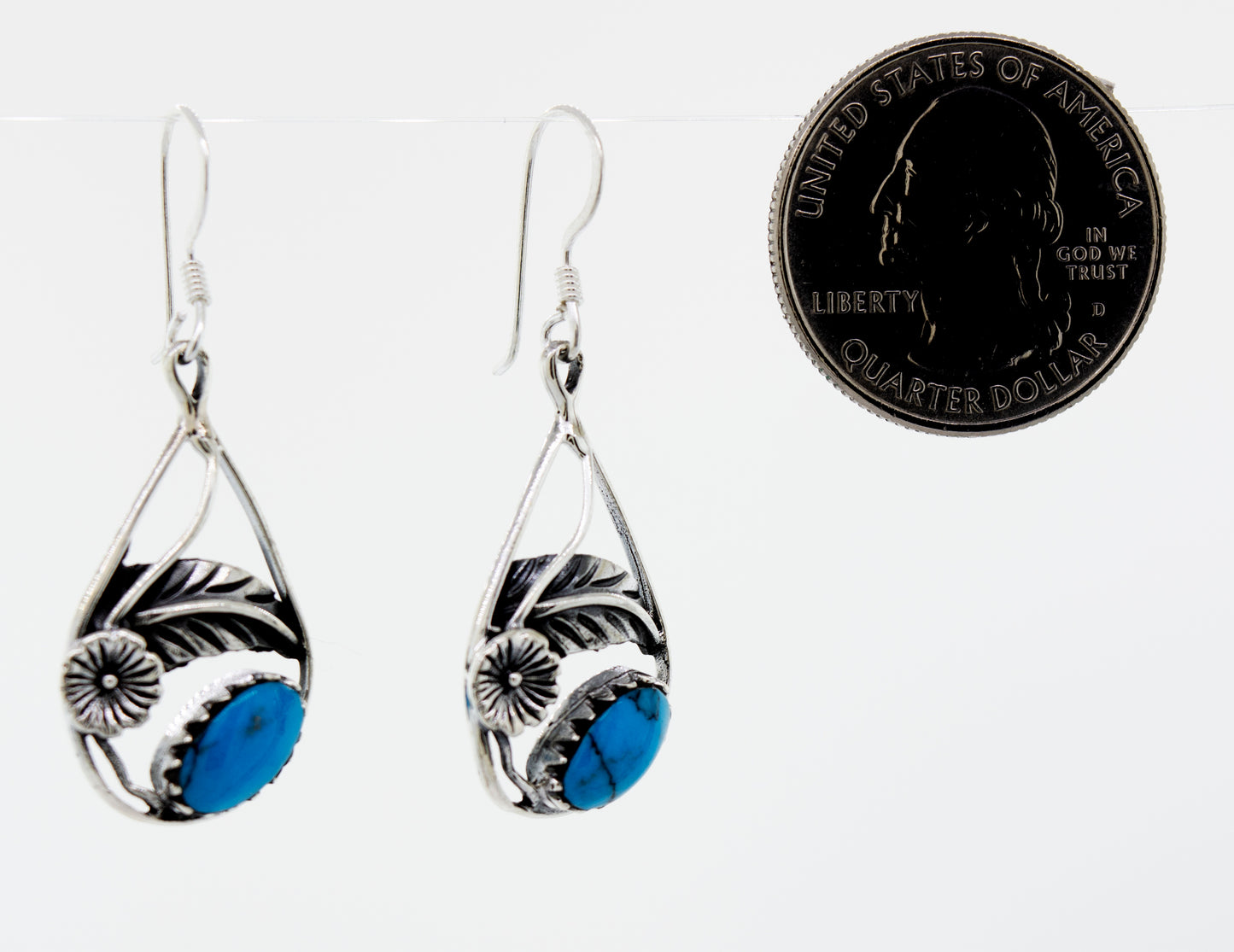 
                  
                    A pair of Blue Turquoise Teardrop Earrings With Floral Setting by Super Silver with a quarter accent.
                  
                