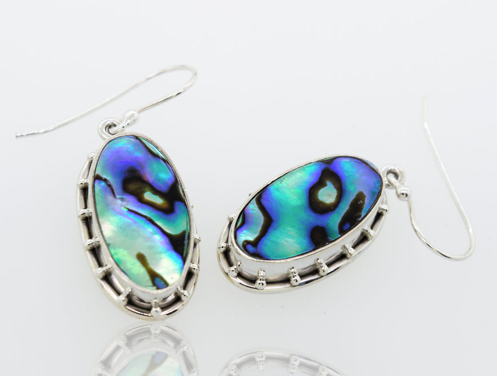 Super Silver Oval Abalone earrings on a white surface.