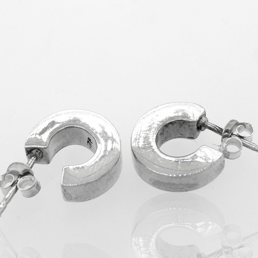 
                  
                    A pair of Super Silver Sterling Silver Half Hoop Stud Earrings on a white surface.
                  
                