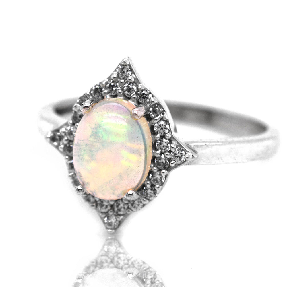 An Elegant Ethiopian Opal ring with Cubic Zirconia stones on a white background.