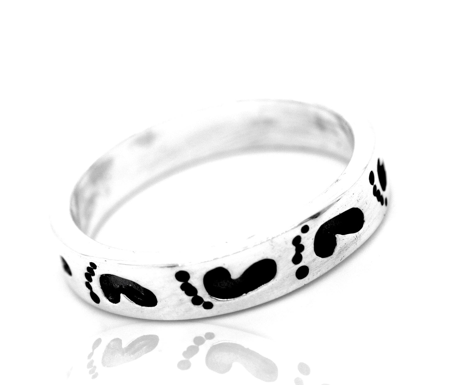 A Super Silver Footprint Band Ring with black footprints, perfect for the beach lover in your life.