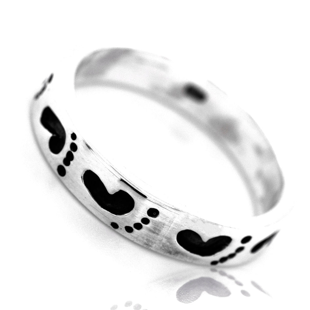 A Super Silver Footprint Band Ring with black hearts on it, perfect for the beach lover.