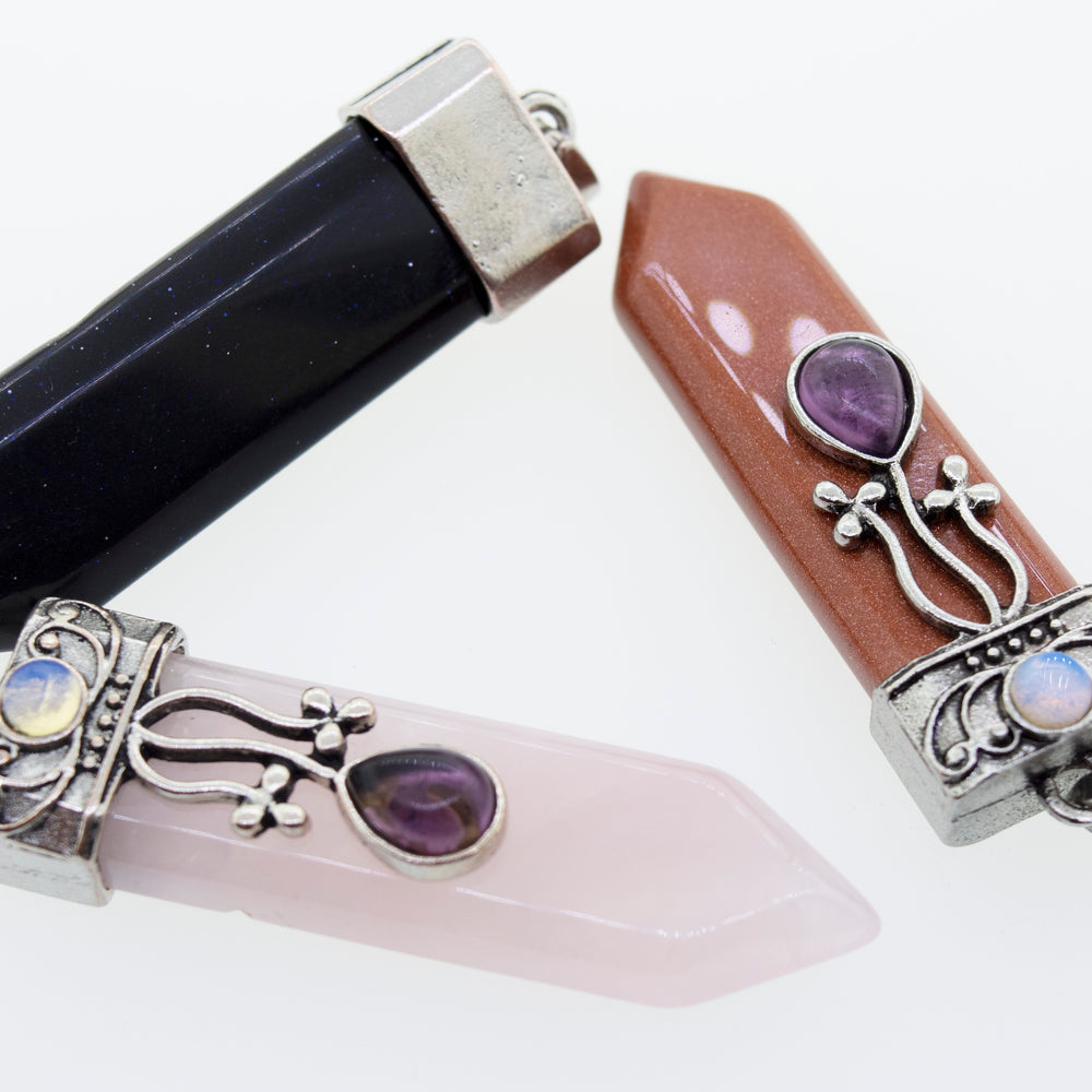 
                  
                    Three Obelisk Crystal Stone Pendants, each uniquely set in a Super Silver silver-plated setting, perfect for adding a touch of Boho style to any outfit.
                  
                