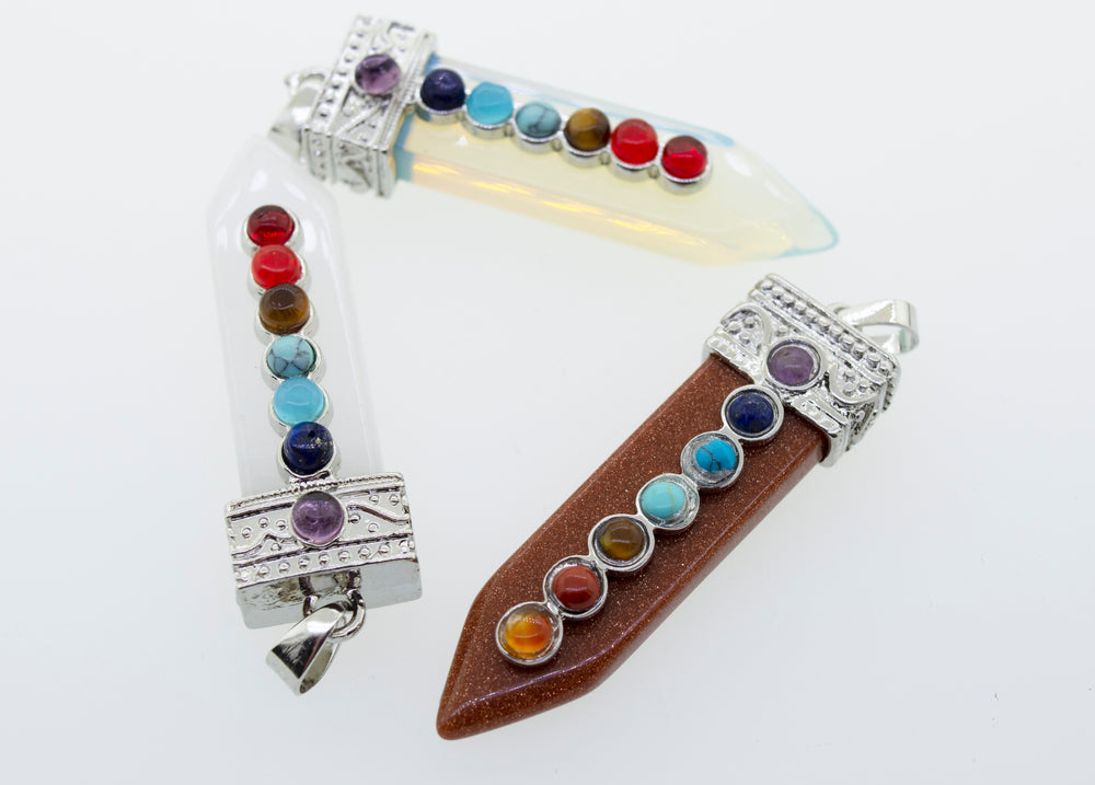 
                  
                    A Obelisk Crystal Pendant with Small Chakra Stones adorned with a variety of chakra stones and a silver-plated design. (Brand name mentioned)
                  
                