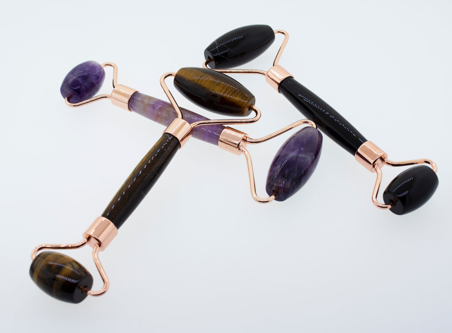 This description features Stone Face-rollers made of tiger eye, amethyst, and rose quartz stones. Incorporating the keywords "face roller" and "stone," it highlights these tools as part of a self-care.