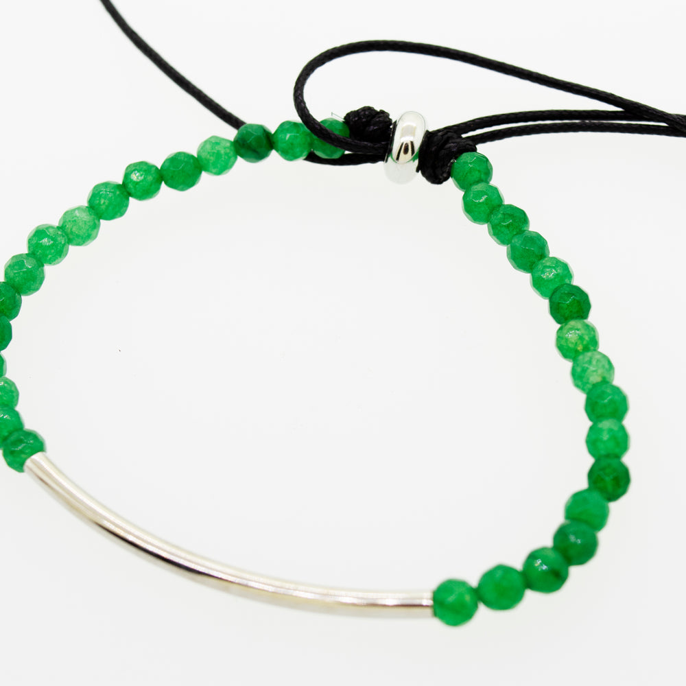 
                  
                    A Super Silver Adjustable Gemstone Bead Bracelet with a green beaded band and a sleek silver bar.
                  
                