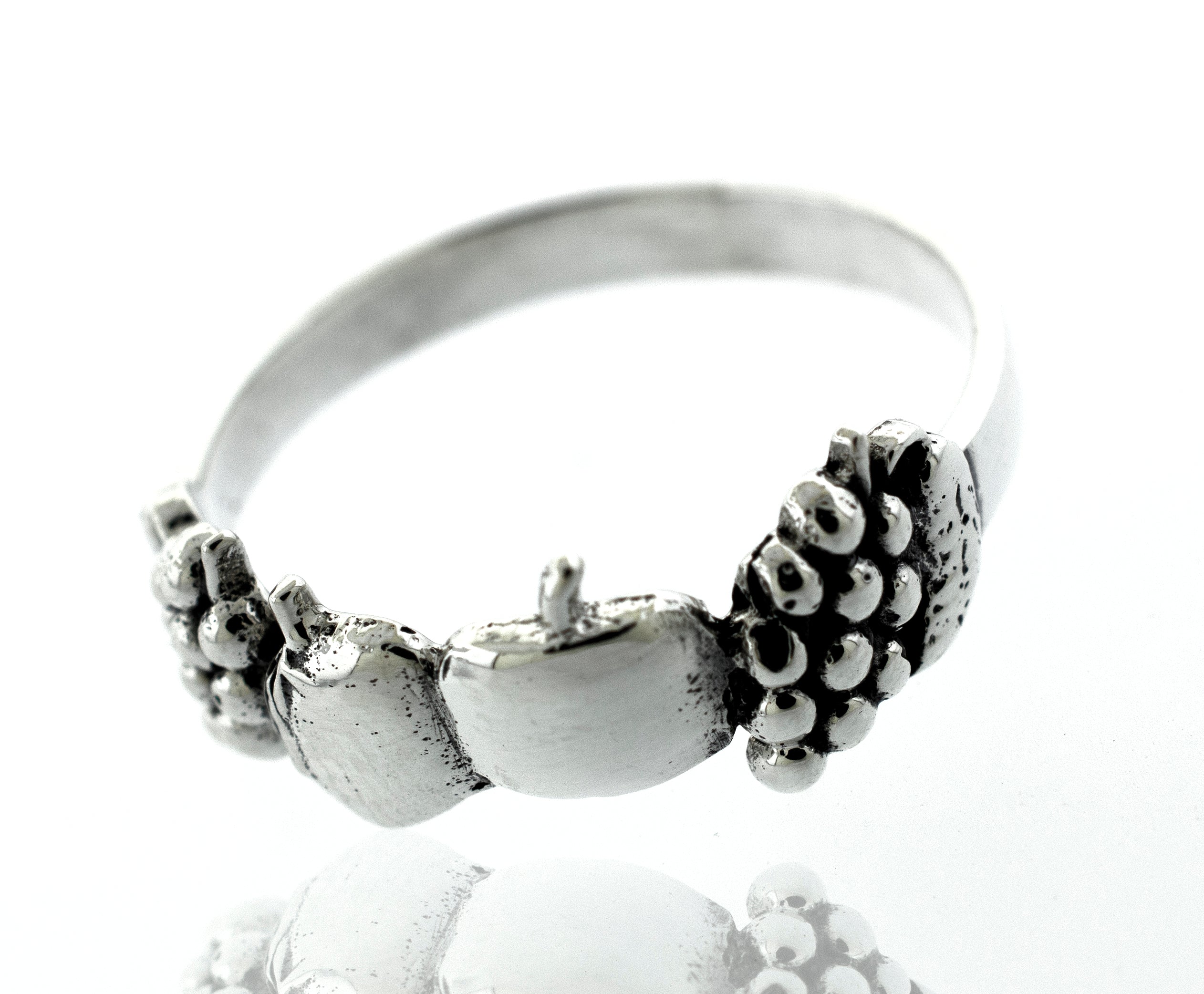 A minimalist Apples And Grapes Design Ring adorned with a dainty apple.