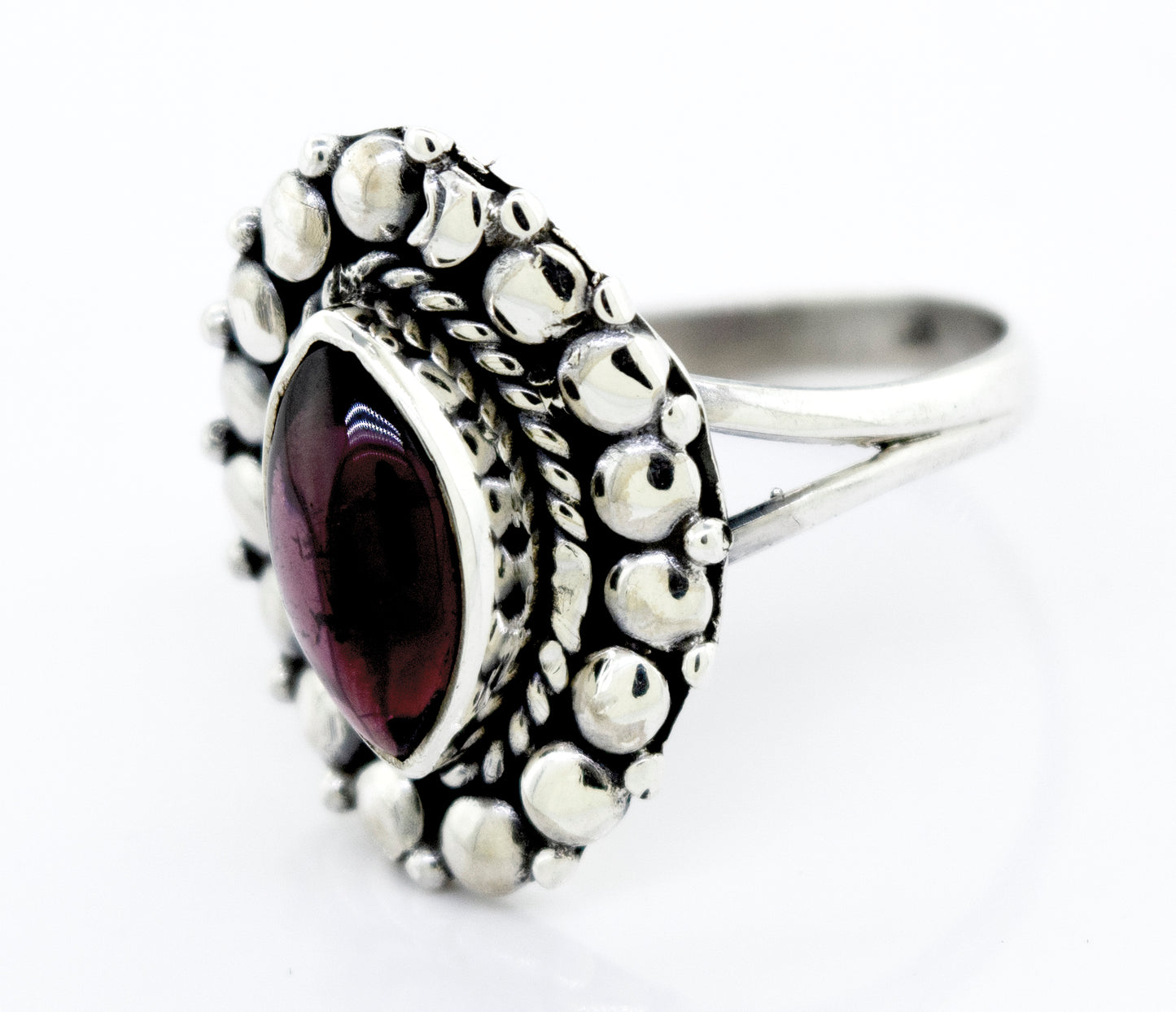 
                  
                    A Marquise Shaped Vibrant Garnet Ring by Super Silver, featuring a beaded design in the silver setting.
                  
                