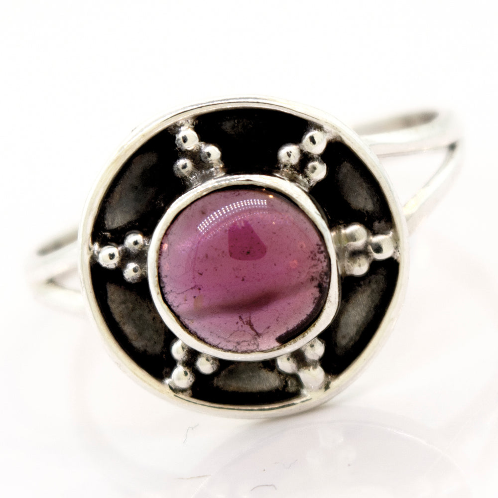 
                  
                    A Super Silver garnet ring with a unique oxidized silver design, featuring a pink stone in the center and an oxidized silver shield design.
                  
                