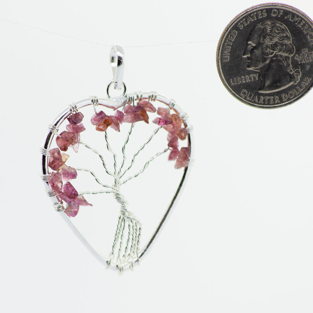 
                  
                    A Super Silver heart-shaped pendant featuring a wire-wrapped pink Heart Shaped Tree of Life Pendant.
                  
                