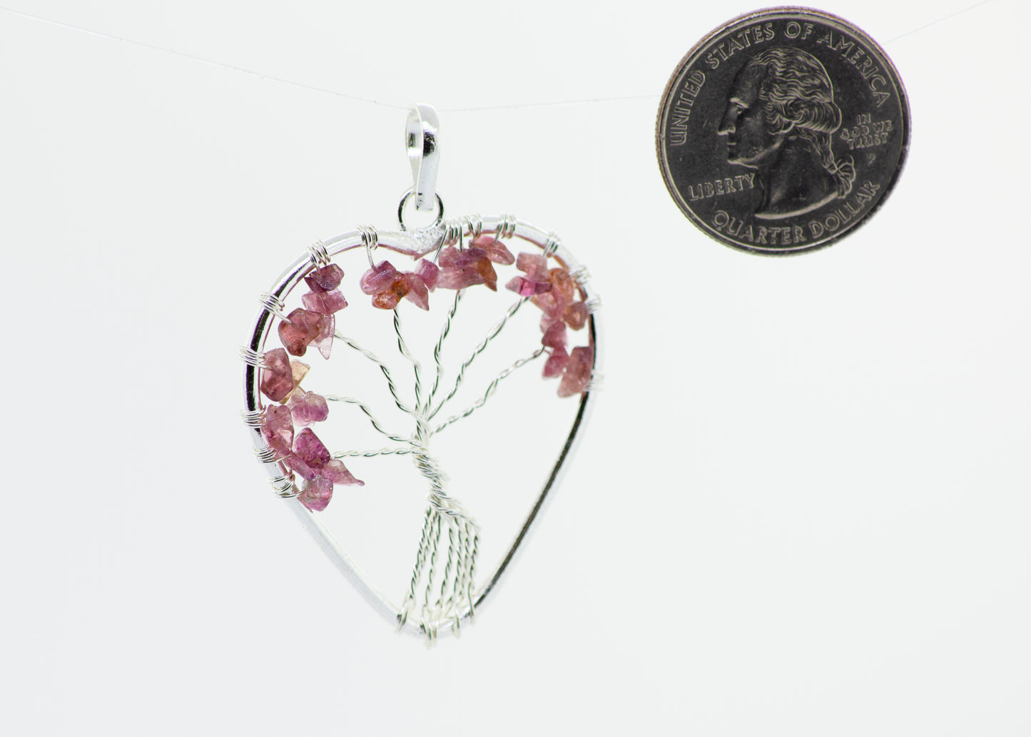 
                  
                    A Super Silver heart-shaped pendant featuring a wire-wrapped pink Heart Shaped Tree of Life Pendant.
                  
                
