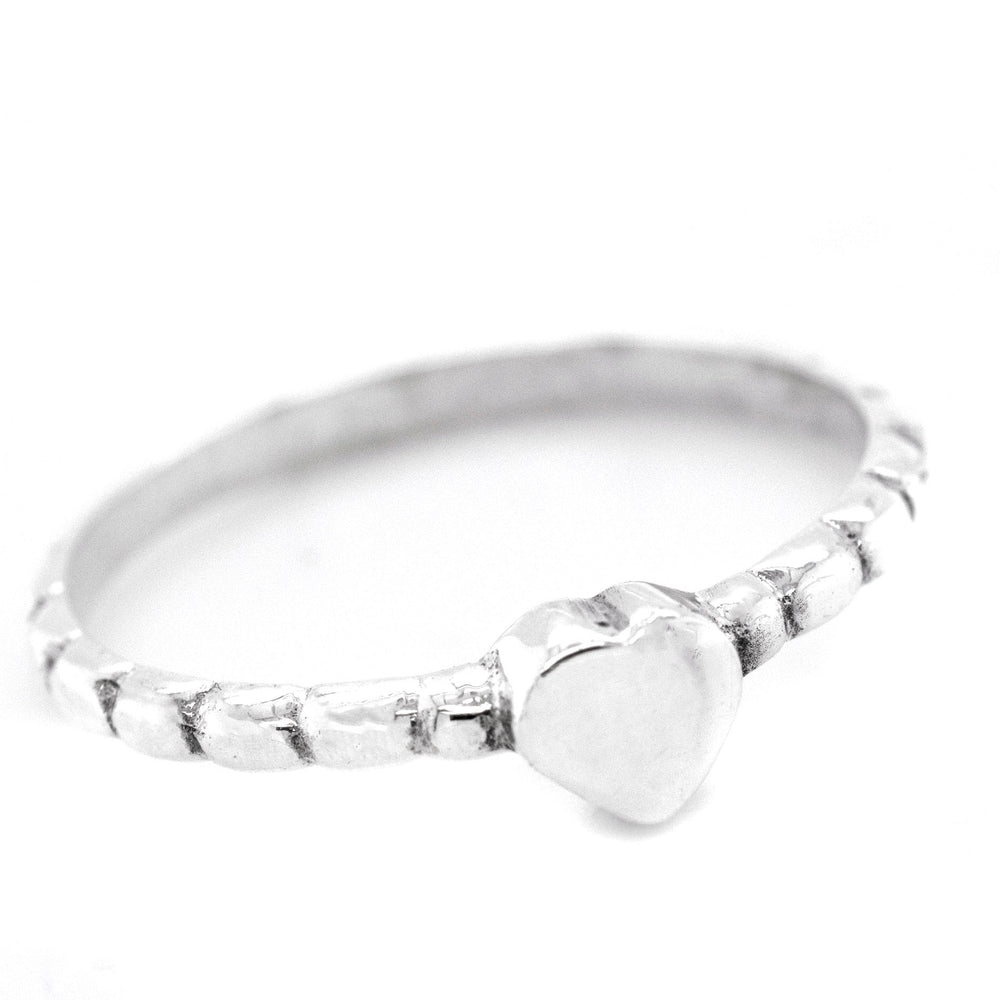 
                  
                    A sterling silver ring with a Petite Patterned Heart Band on a white background.
                  
                