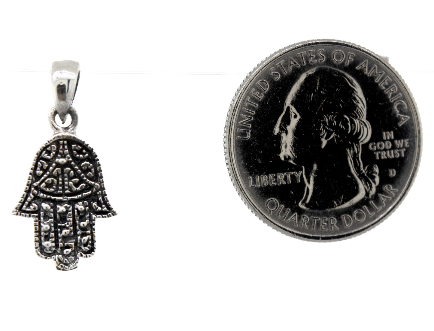 
                  
                    A Super Silver small Hamsa hand pendant made of sterling silver next to a dime.
                  
                