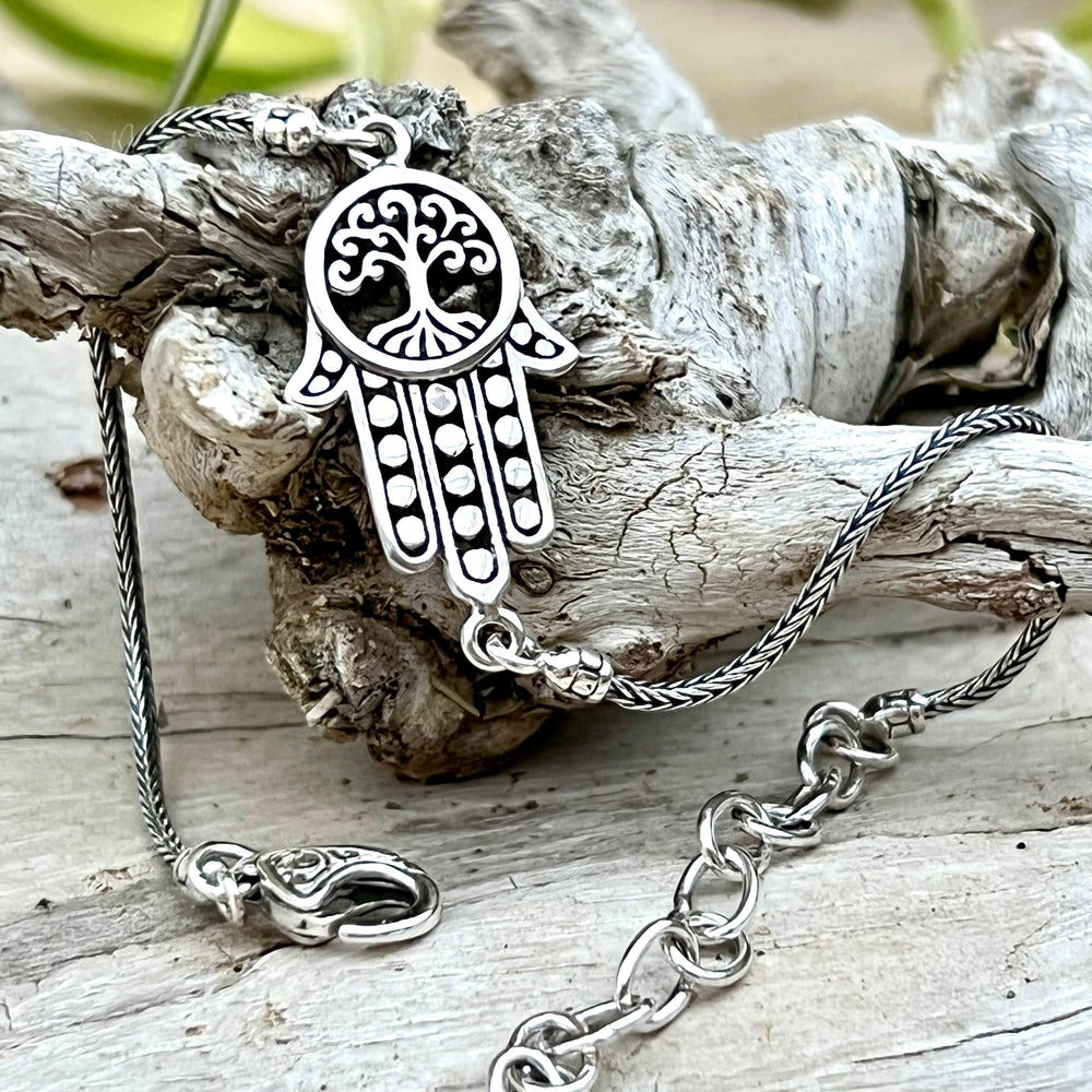 An elegant Hamsa with Tree of Life Bracelet by Super Silver, perfect for everyday wear, delicately crafted and displayed on a piece of wood from our Artisan Collections.