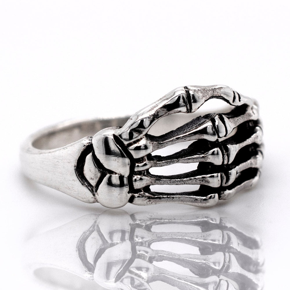 A gothic silver Skeleton Hand Ring on a white background.