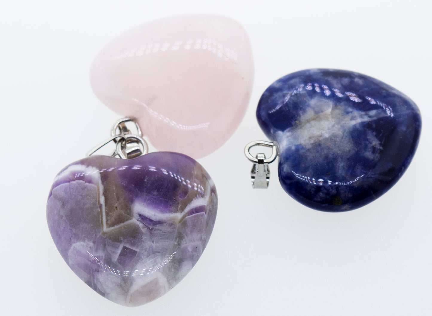 Three Super Silver Heart Stone Pendants, suitable for everyday wear, displayed on a white surface.